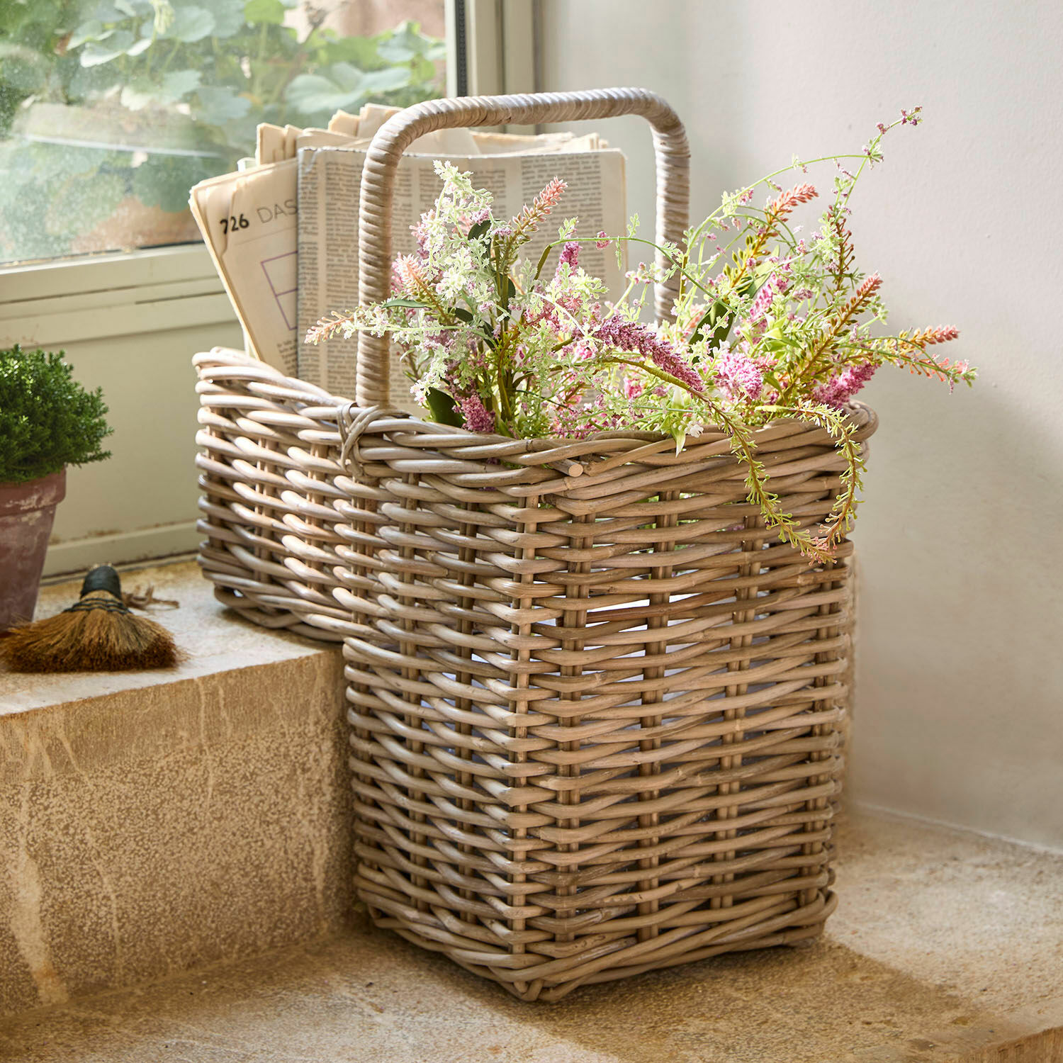 Korb Merveillette Natürlicher Rattankorb mit Blumen und Zeitungen, dekorativ und praktisch für Innenräume.