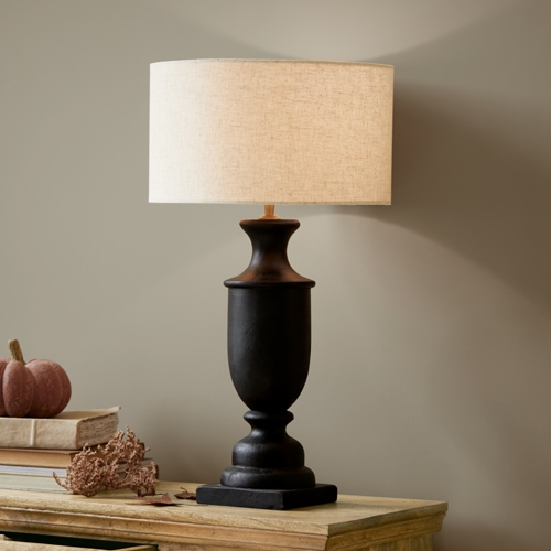 Schwarze Keramik-Tischlampe mit beigem Lampenschirm auf Holztisch, Wohnraumdekoration