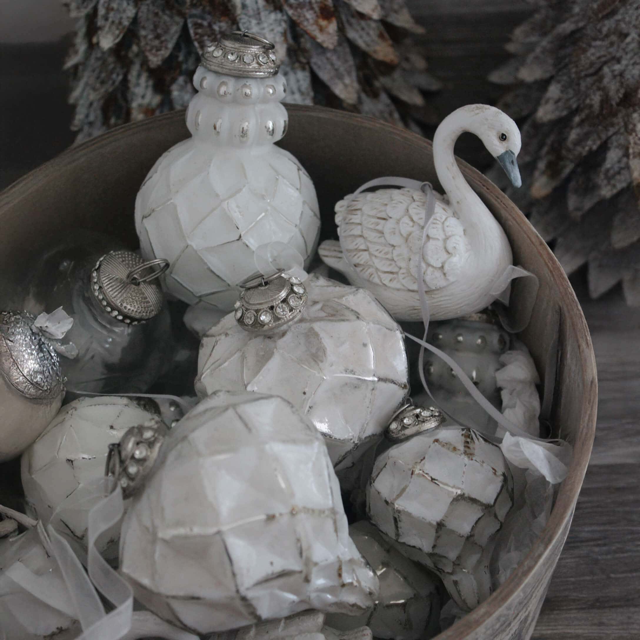 Weisse Weihnachtsdekorationen aus Keramik und Glas in einer Holzkiste, winterliche Ornamente