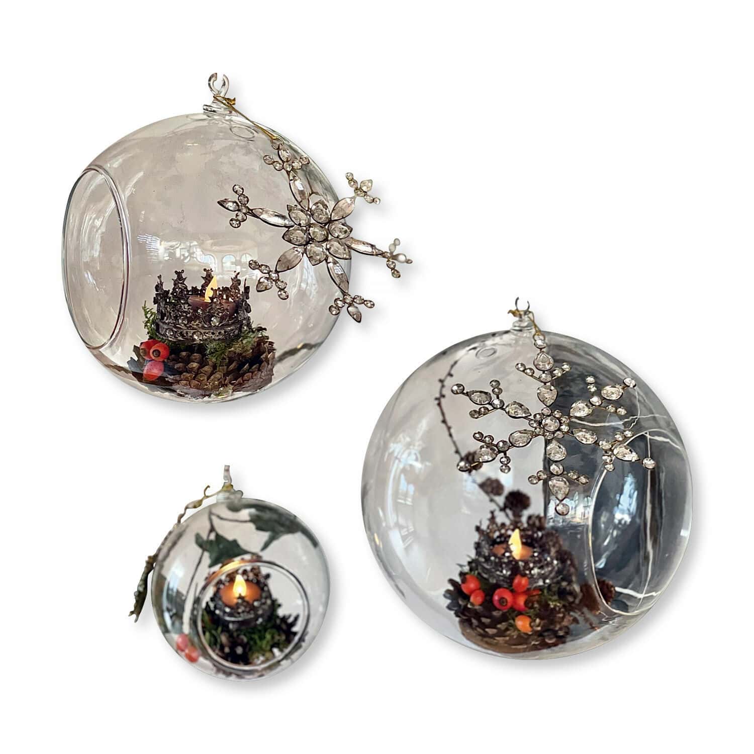 Transparente Glaskugeln mit Weihnachtsdekoration und Kerzen, verziert mit Kristallschneeflocken