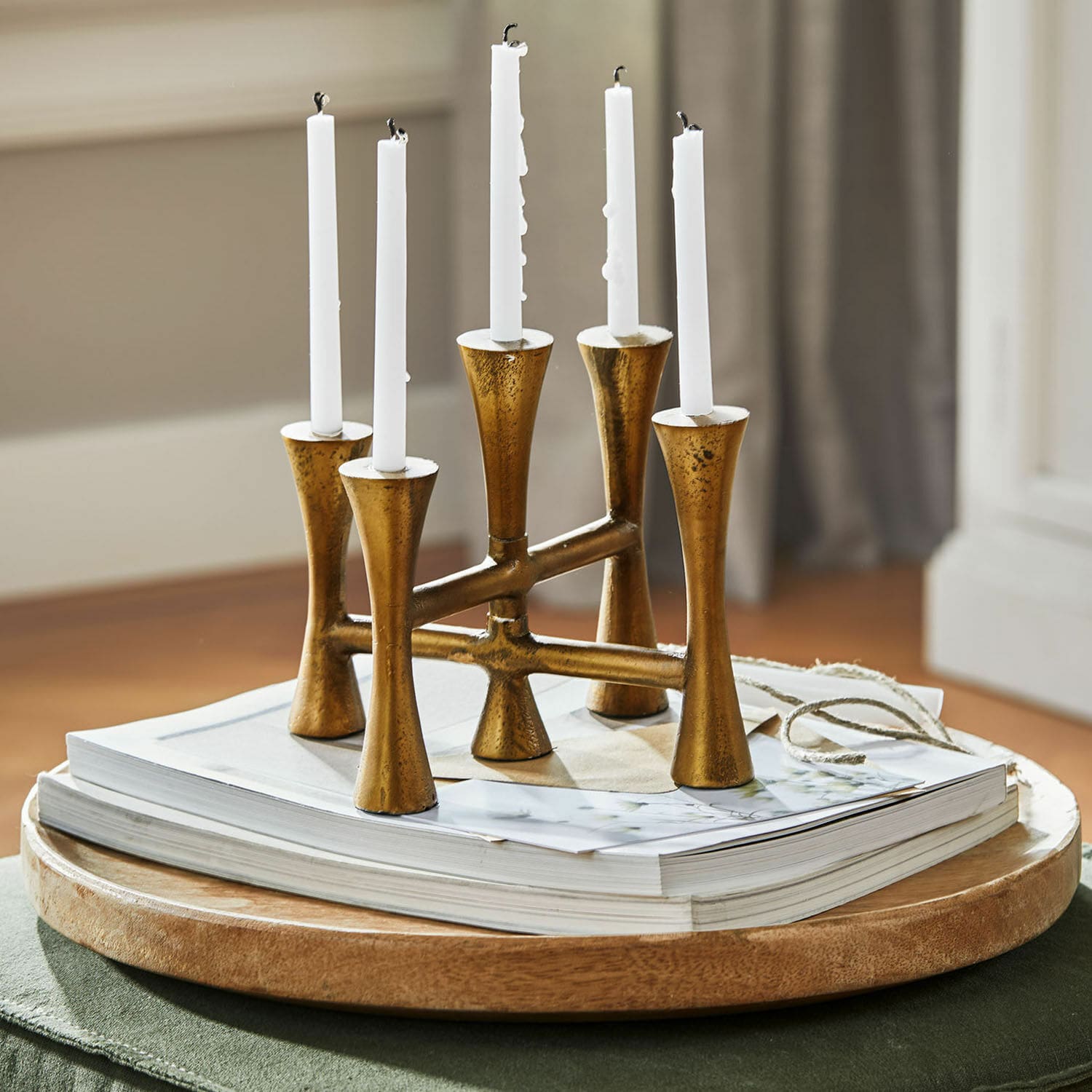 Kerzenständer Feroze Goldener Metallkerzenhalter für fünf weisse Kerzen auf Holztablett mit Büchern, Wohnaccessoire