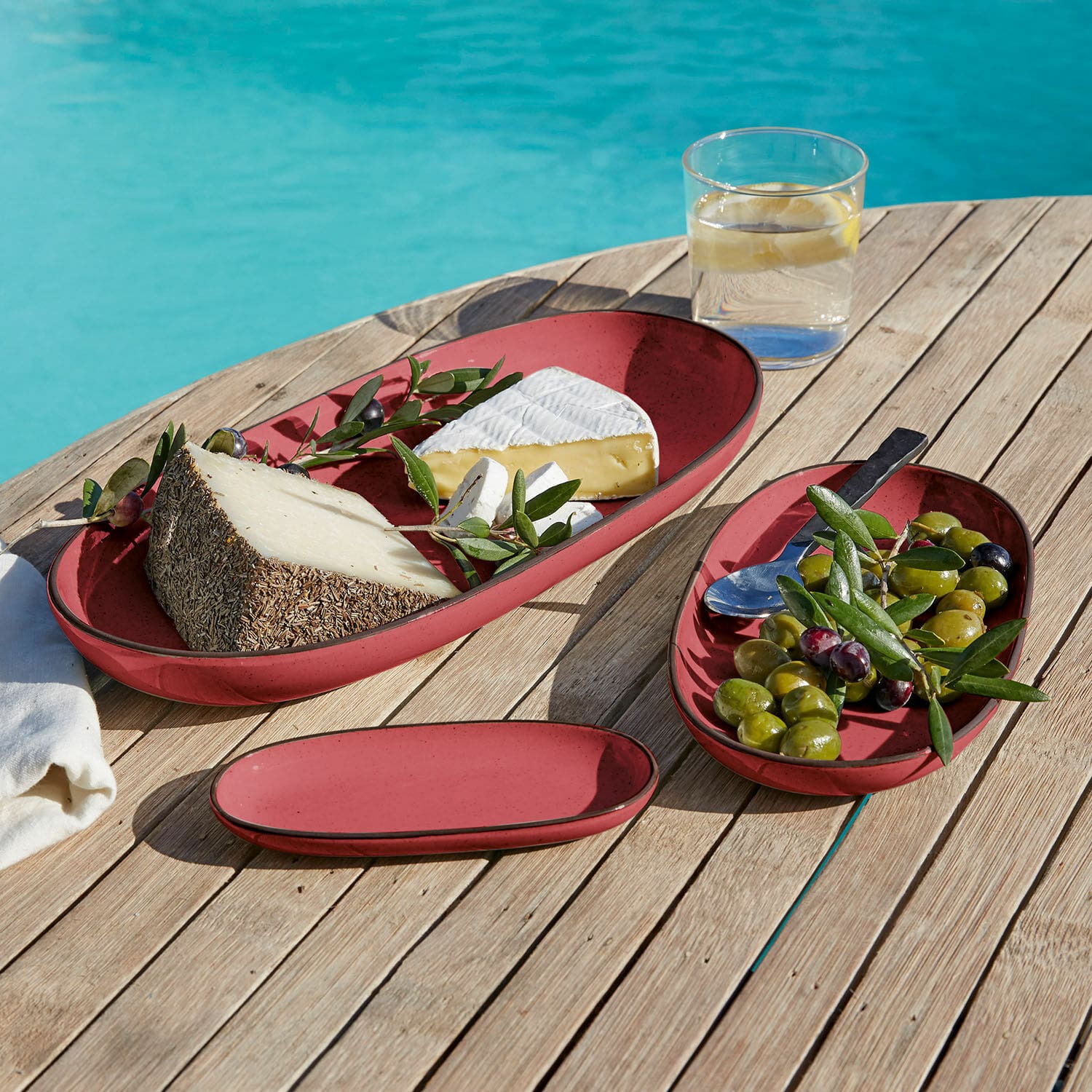 Servierplatte 3er Set Biarré Rote ovale Keramikteller mit Käse und Oliven auf Holztisch beim Pool