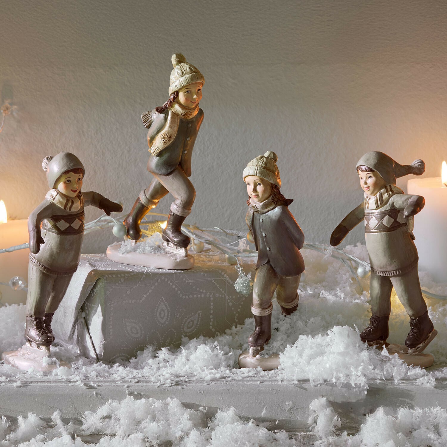 Figur 4er Set Mériot Keramikfiguren von Kindern beim Schlittschuhlaufen in Beige und Grau auf winterlich dekoriertem Tisch