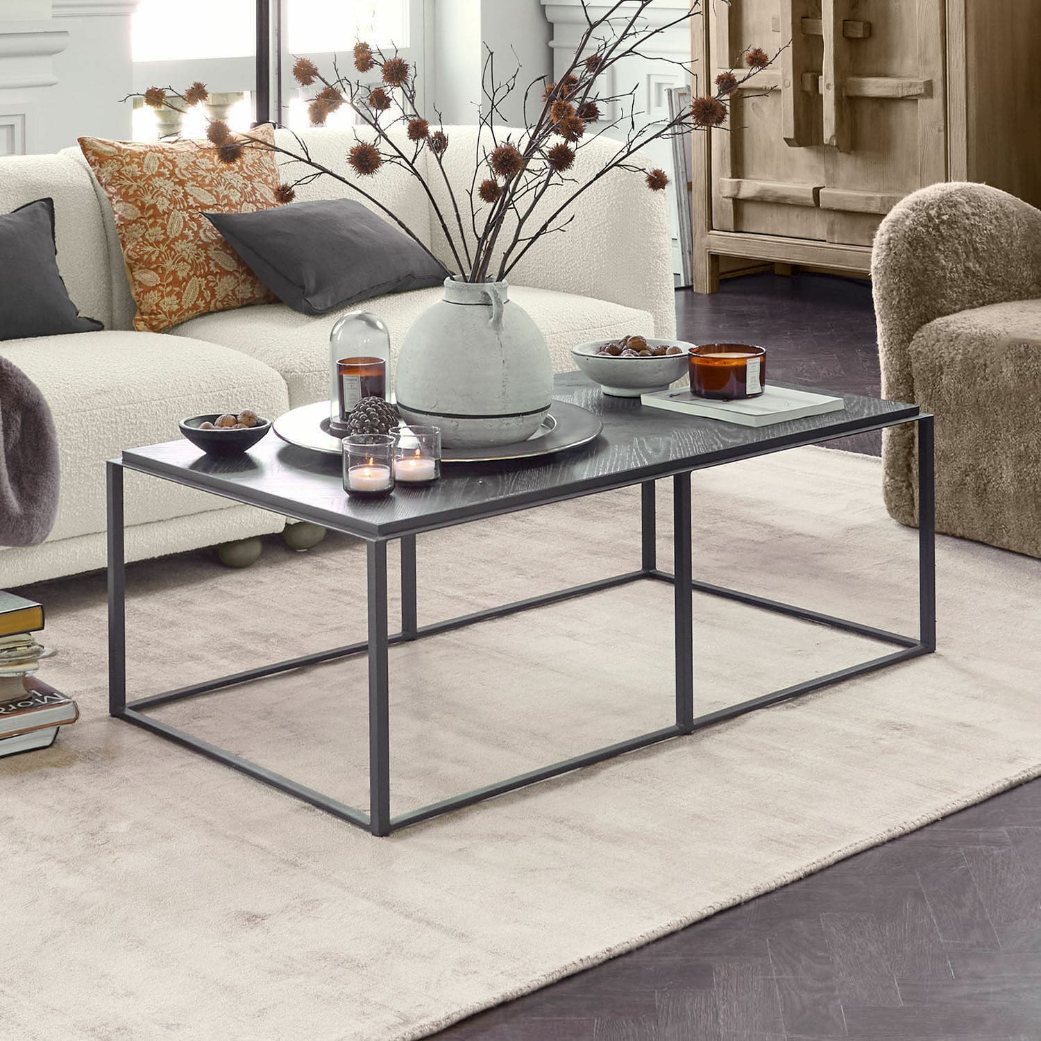 Couchtisch Lumesto Moderner schwarzer Couchtisch mit Metallgestell und Dekorationen im hellen Wohnzimmer mit beigem Sofa