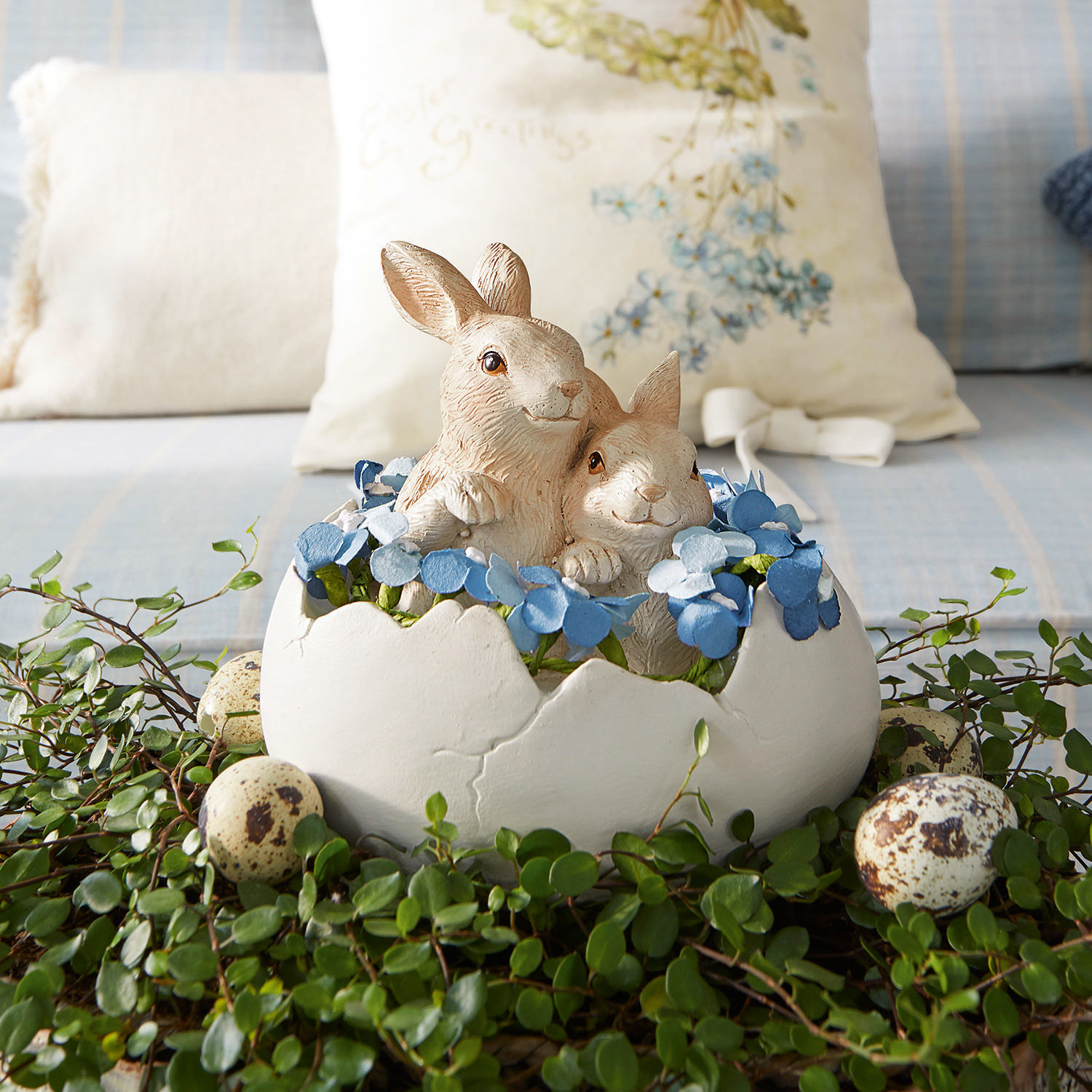 Hasen mit Ei Miksa Dekoration mit zwei Hasen in weisser Eierschale, blauen Blumen und grünem Blattwerk