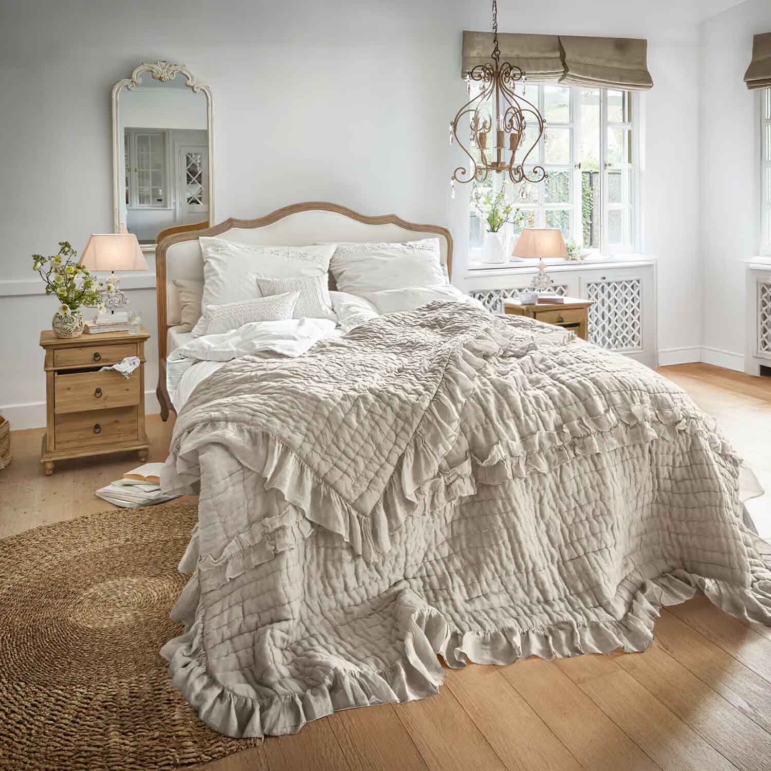 Gemütliches Schlafzimmer mit Bett in beiger Rüschendecke und hellen Holznachtischen