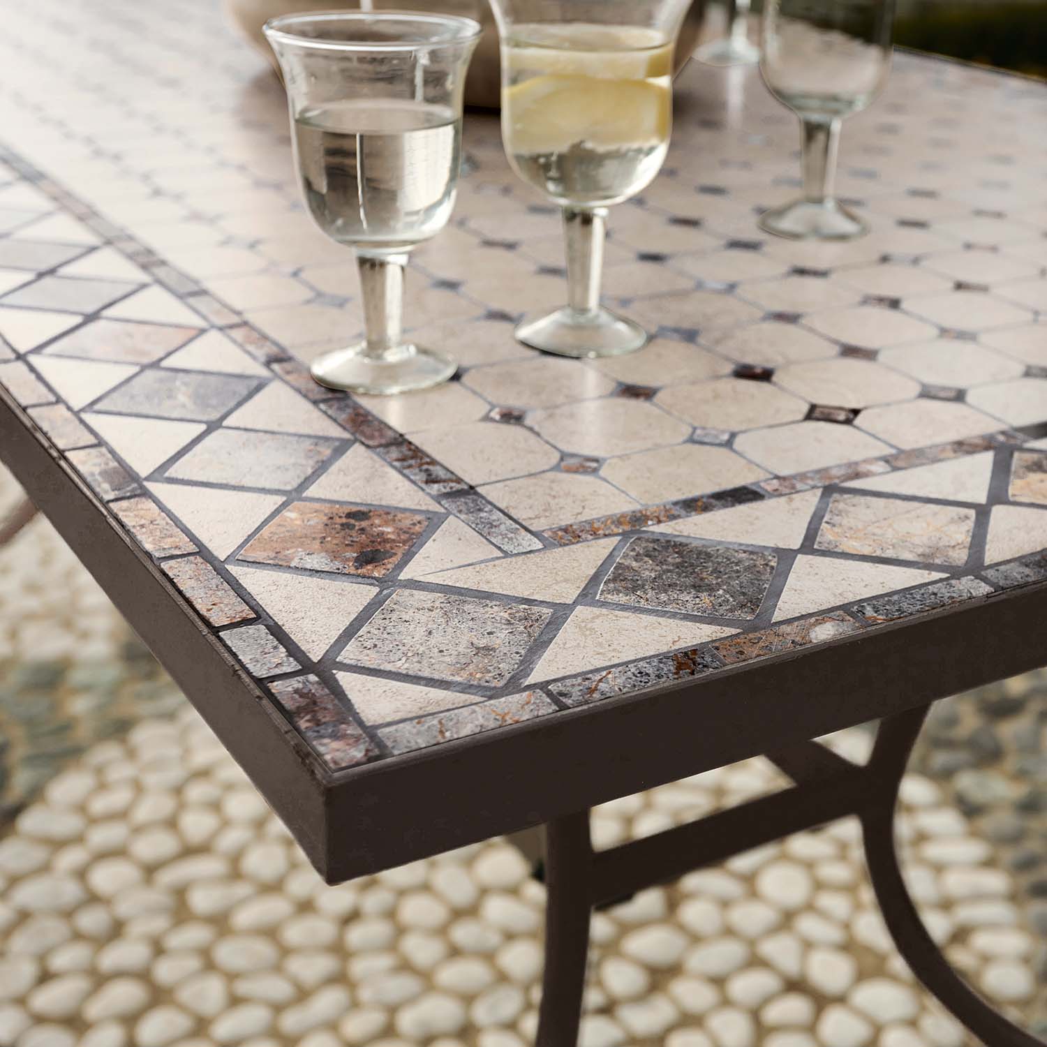 Gartentisch mit Steinmosaik in Beige- und Brauntönen, Metallrahmen und klaren Gläsern