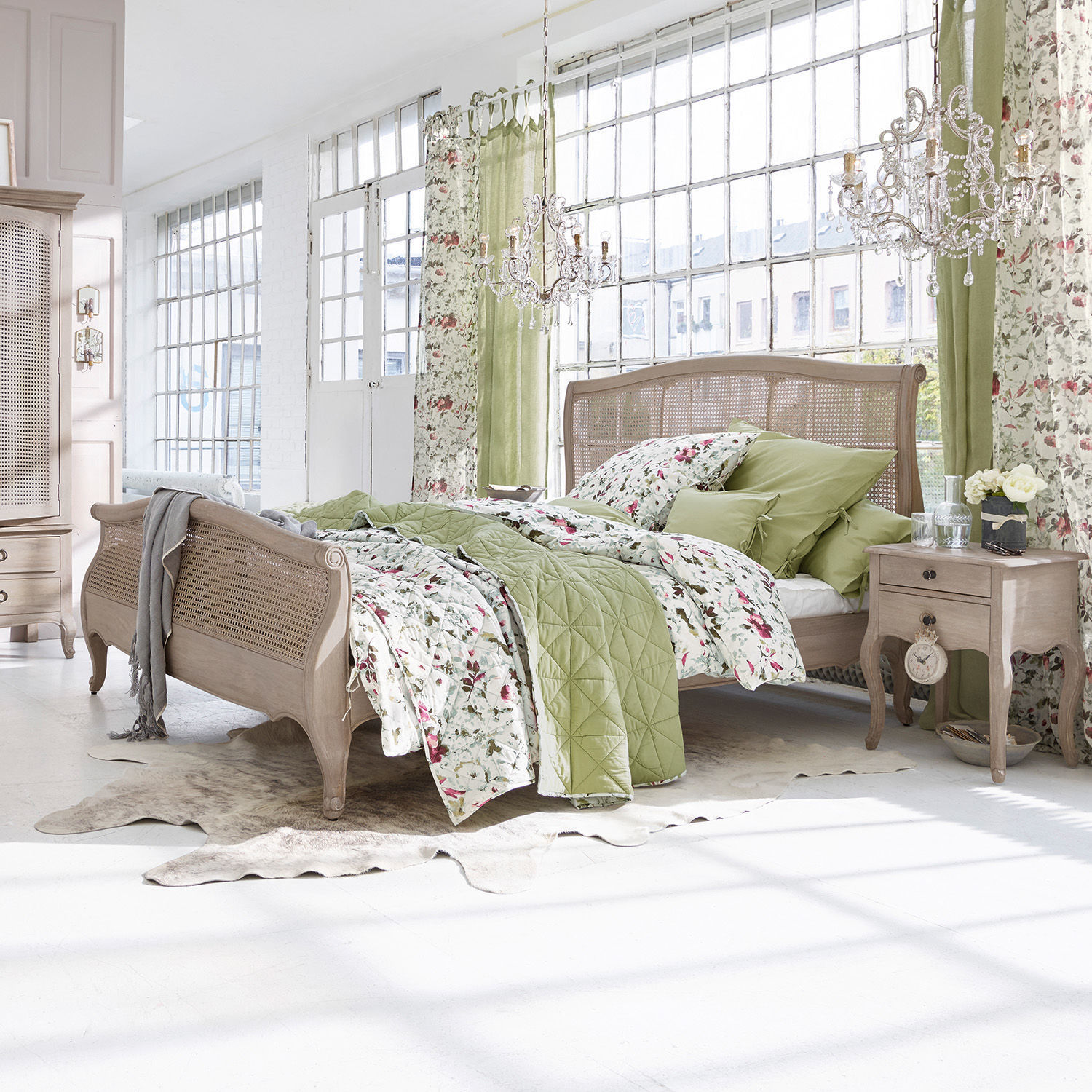 Bett Truso Schlafzimmer mit Holzbett und grün-blumiger Bettwäsche im hellen, natürlichen Stil