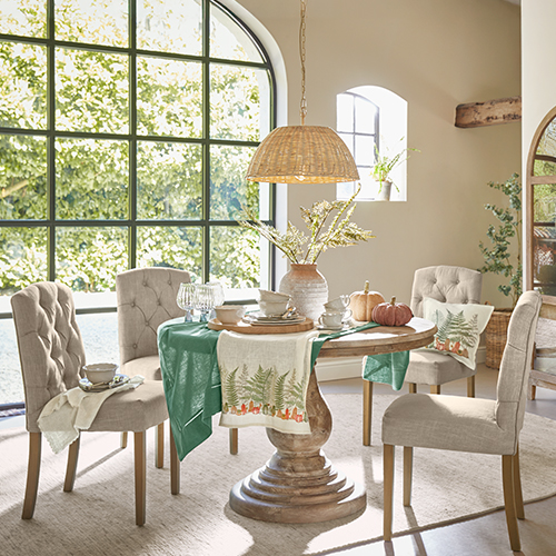 Esszimmer mit rundem Holztisch und beige gepolsterten Stühlen, natürliche Dekoration und Tageslicht