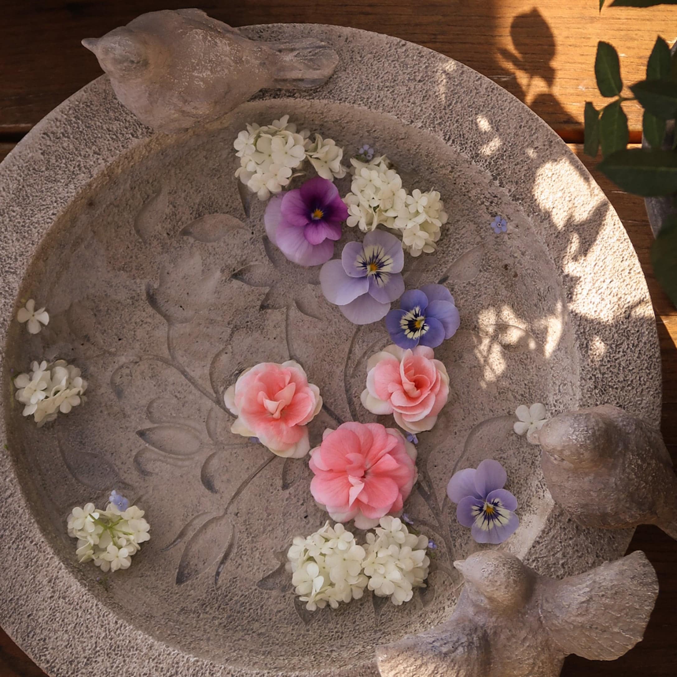 Dekorativer Steinteller mit Vogel- und Blumenmotiv, ideal für Garten- oder Wohnraumdekoration.