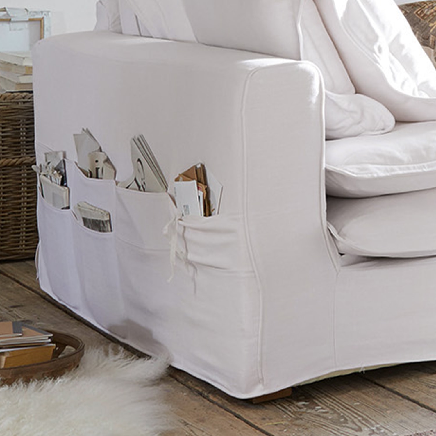 Weisses Baumwollsofa mit praktischen Seitentaschen für Magazine und Bücher im Wohnzimmer