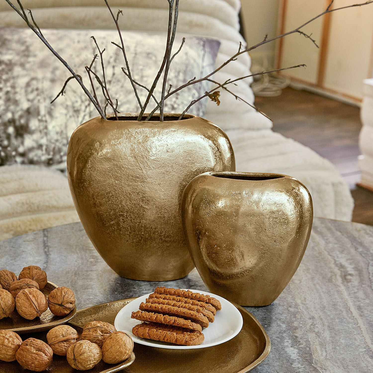 Vase 2er Set Cezelle Set aus zwei goldfarbenen Keramikvasen auf dem Tisch mit Nüssen und Guetzli im Wohnzimmer