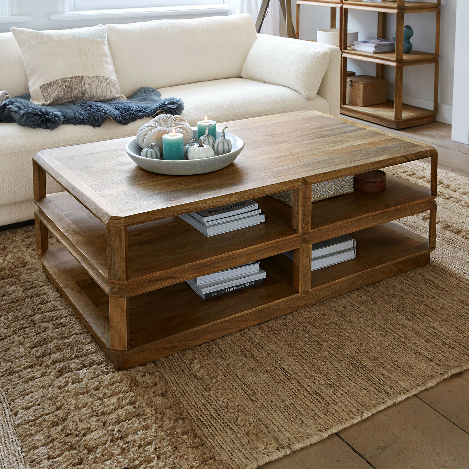 Holz-Couchtisch in Naturfarbe mit Ablageflächen auf beigem Teppich im Wohnzimmer