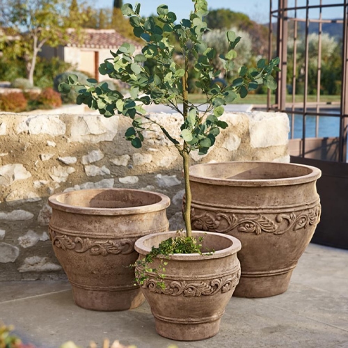 Drei dekorative Terrakotta-Blumentöpfe in Braun mit Reliefmuster, ideal für den Garten.