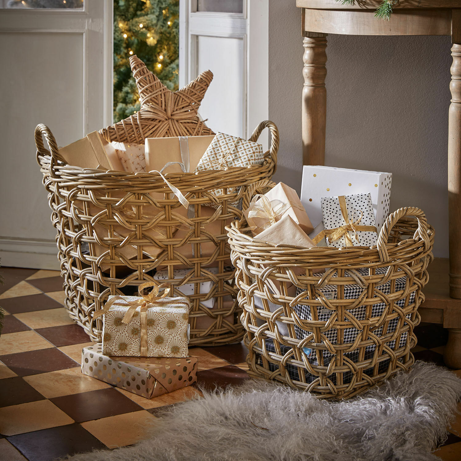 Korb 2er Set Qivoran Zwei naturfarbene Rattankörbe mit Geschenken und Weihnachtsdeko auf gefliestem Boden.