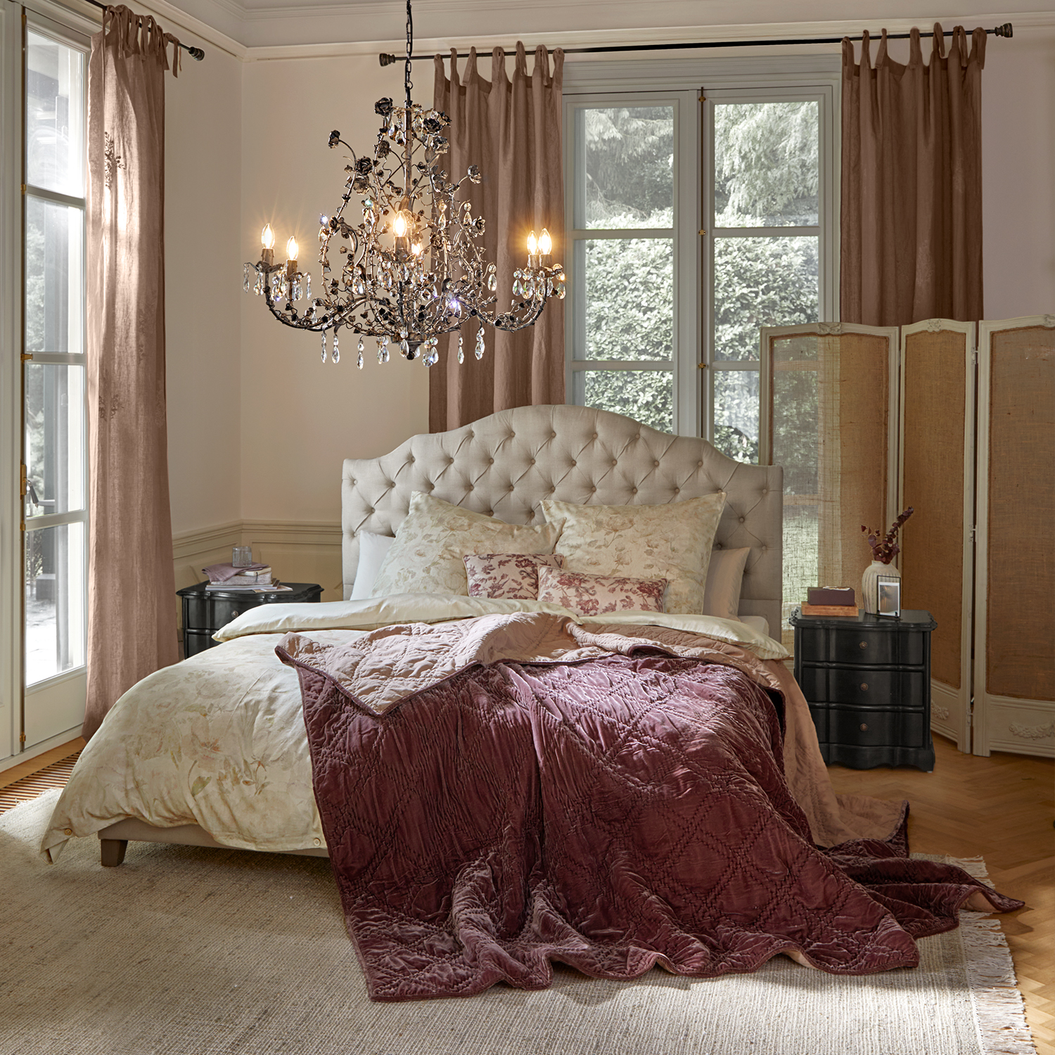 Gemütliches Schlafzimmer mit beigem gepolstertem Kopfteil und bordeauxroter Samtdecke auf dem Bett