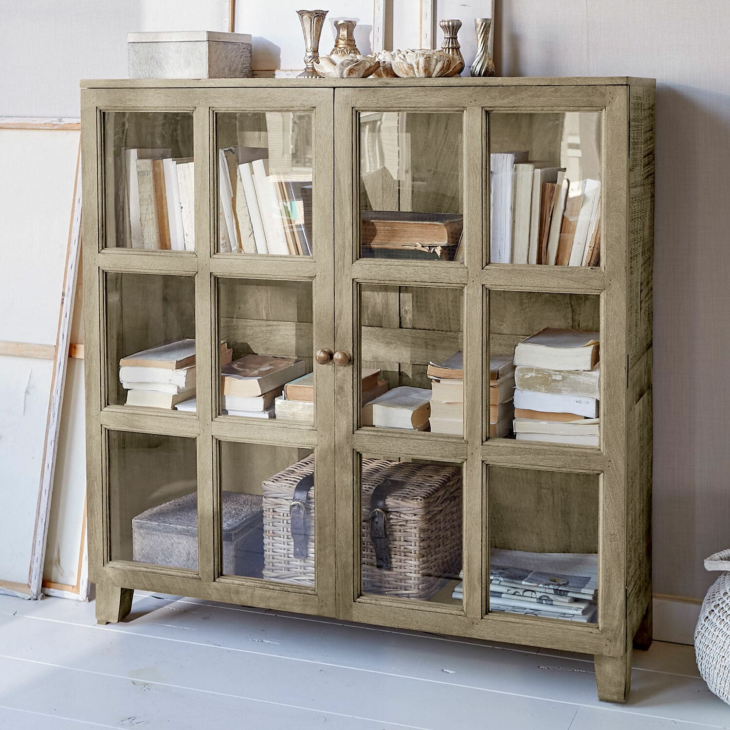 Kommode Stoneham Beige Holzvitrine mit Glastüren, gefüllt mit Büchern und Dekorationen, stilvolles Wohnzimmermöbel