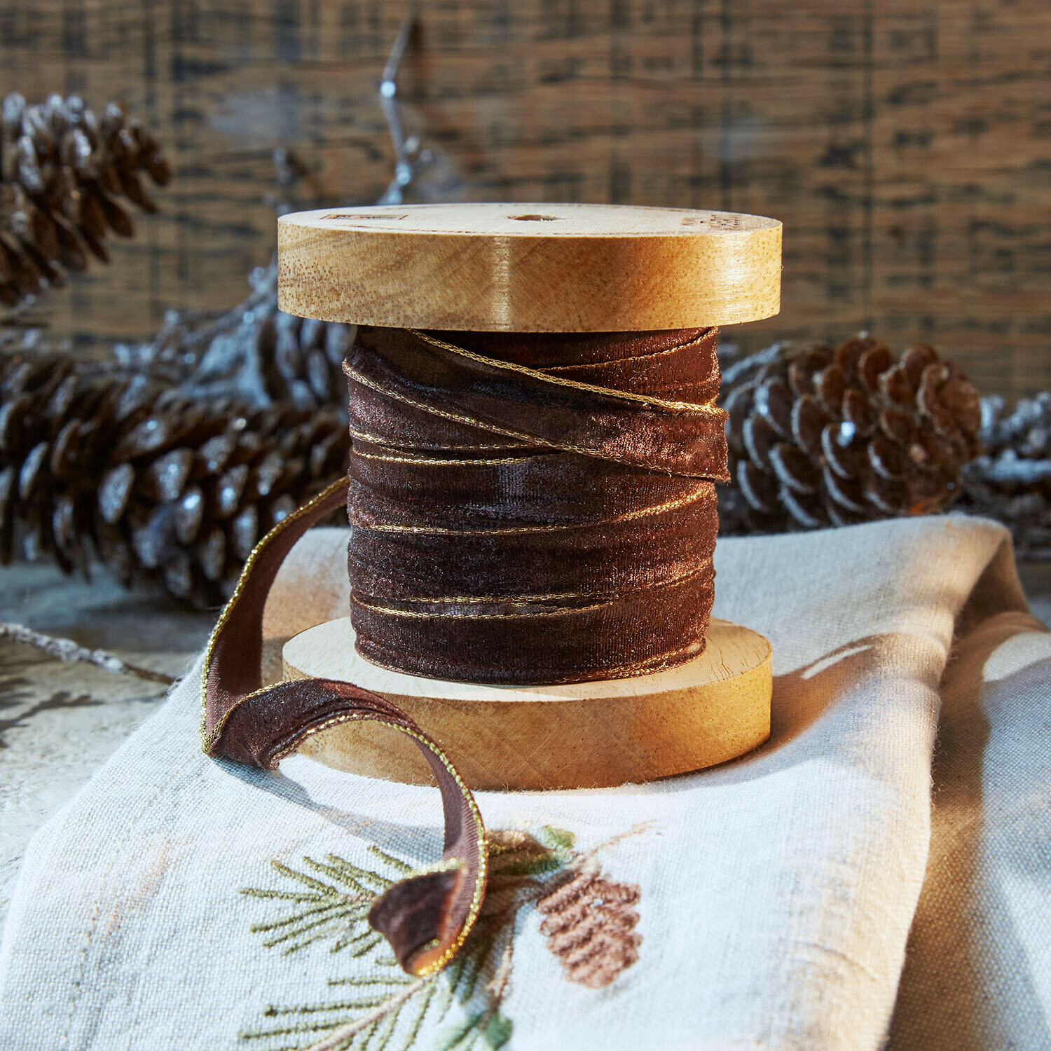Samtband Sorima Braunes Samtband mit goldenem Rand auf Holzspule, festliche Dekoration mit Tannenzapfen