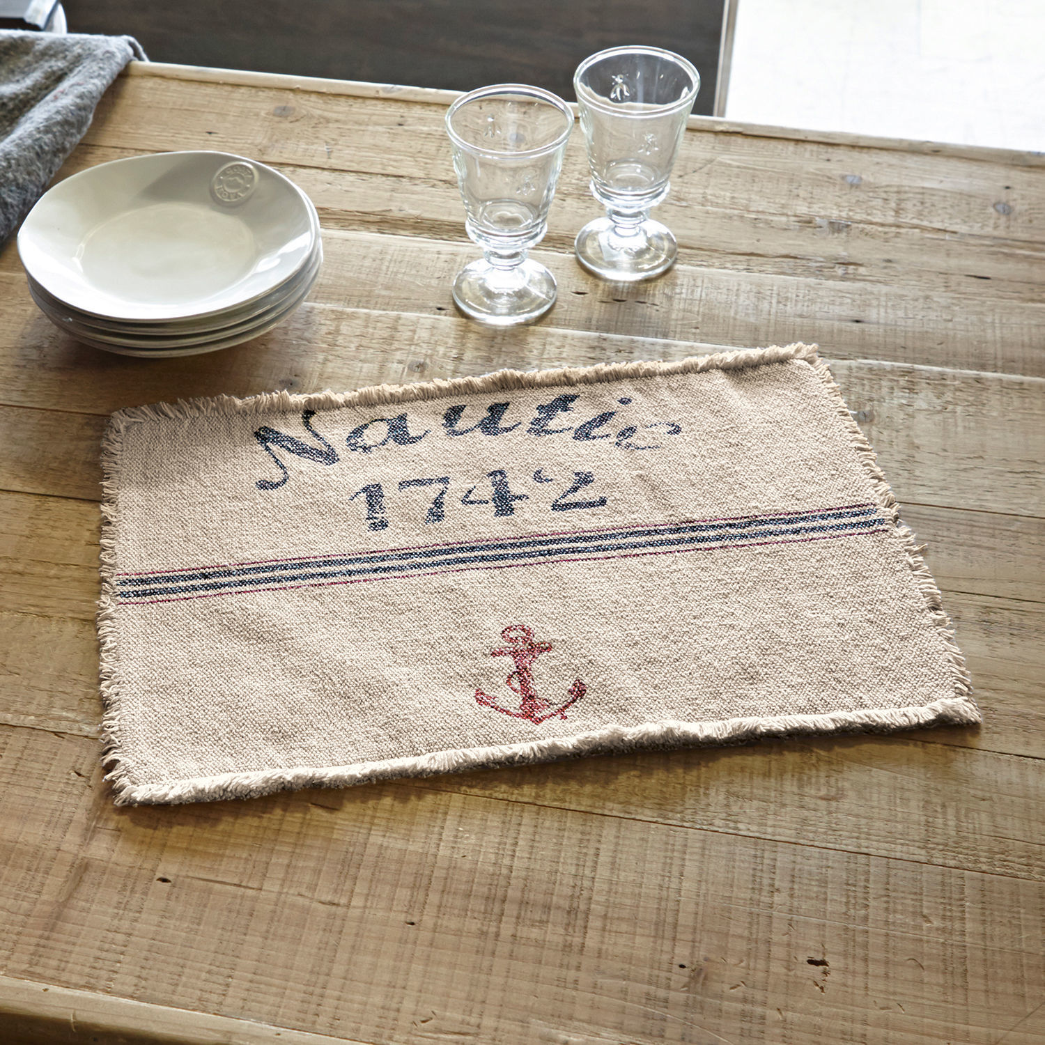 Platzset 2er Set Nautic Beiges Baumwoll-Tischset mit rotem Anker und Schriftzug Nautic 1742 auf Holztisch