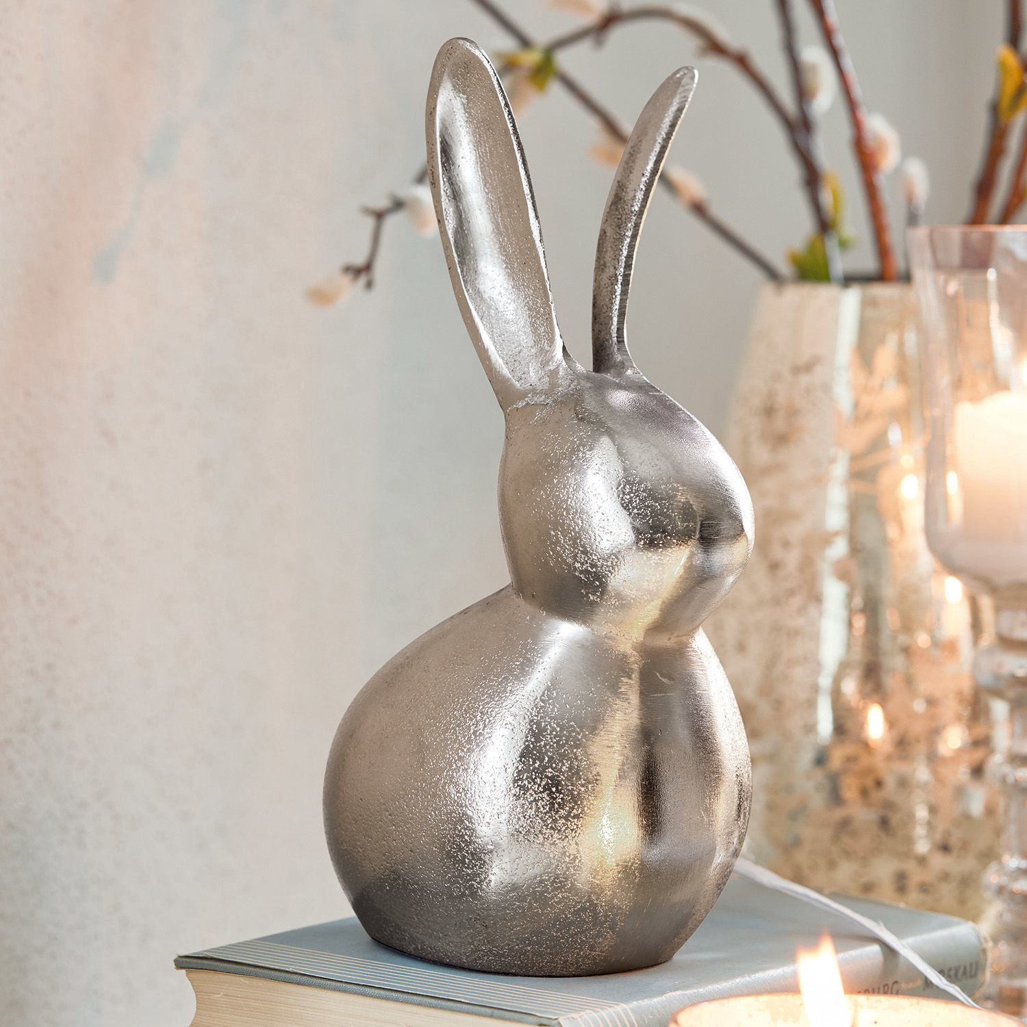 Deko-Hase Benji Dekorativer silberner Metallhase auf Buch, Osterdekoration für das Zuhause