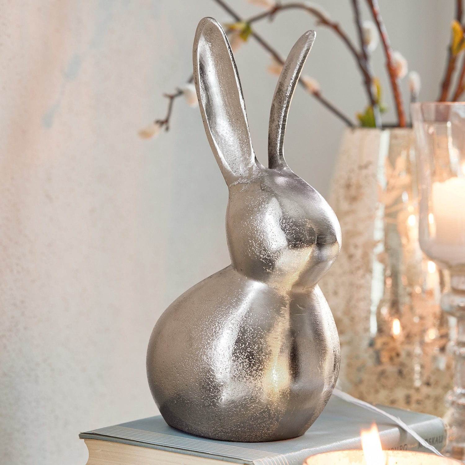 Deko-Hase Benji Dekorativer silberner Metallhase auf Buch, Osterdekoration für das Zuhause