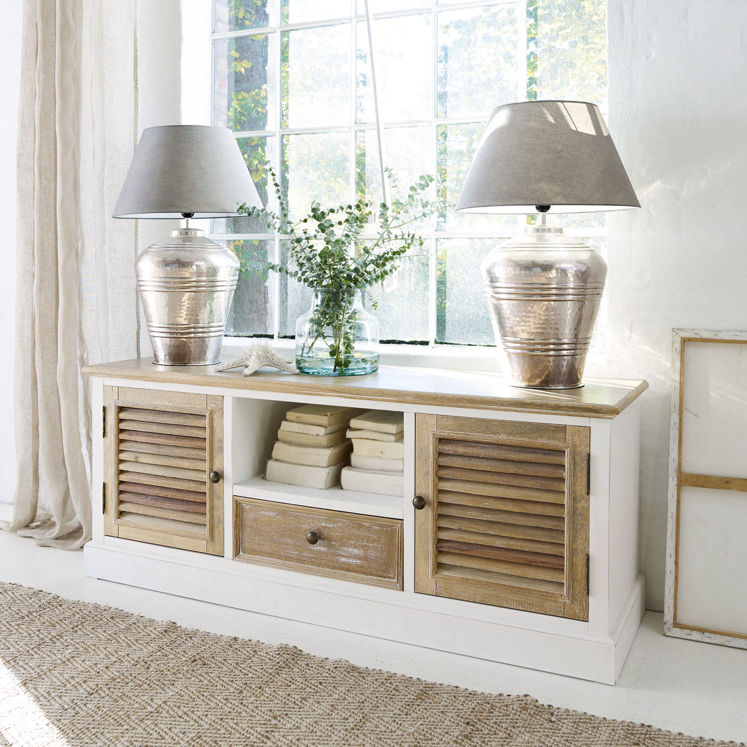 Sideboard Glencoe Weisse Holzkommode mit natürlicher Holzplatte und Lamellentüren, dekoriert mit Lampen und Büchern