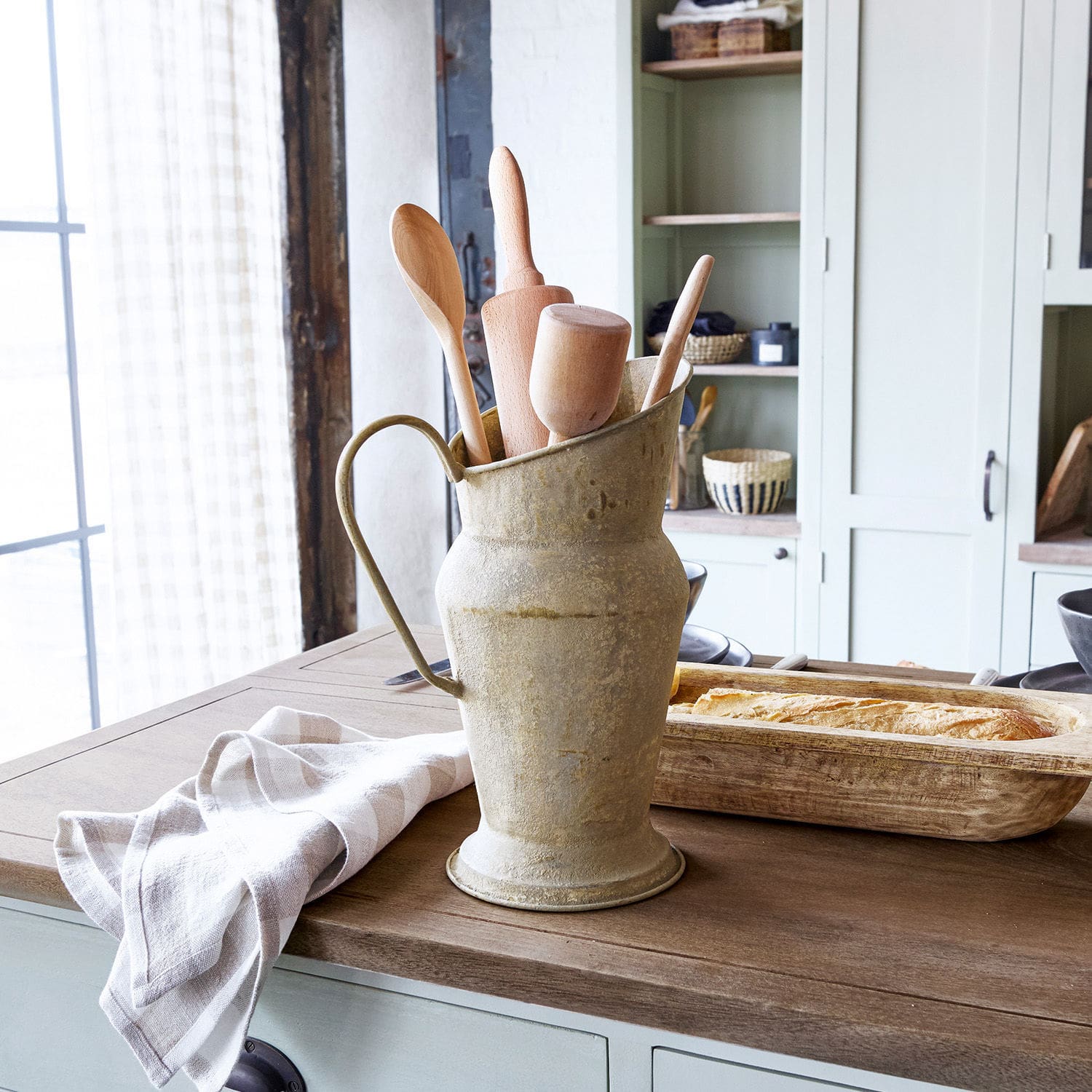 Krug Asante Metallkrug im Vintage-Stil mit Holz-Küchenutensilien auf Holzarbeitsplatte