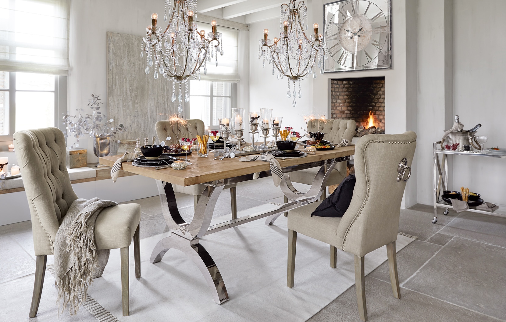 Klassisch elegante Esszimmer mit Holztisch, beigen Polsterstühlen, Kronleuchtern und stilvoll gedecktem Tisch.