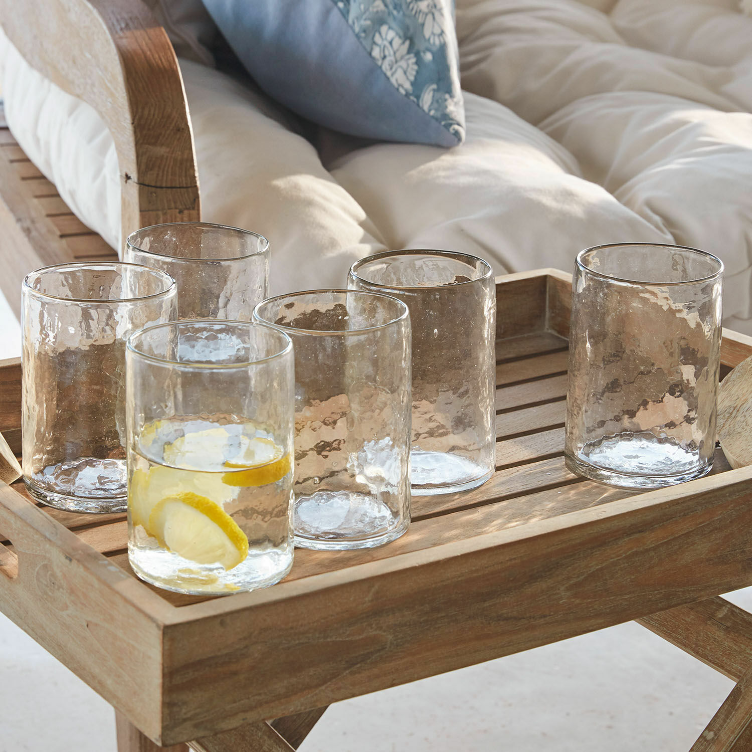 Sechsteiliges Set transparenter, strukturierter Gläser auf Holztablett zum Servieren von Getränken