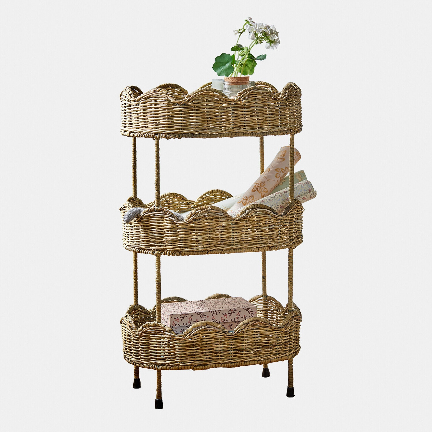 Dreistöckiges Regal aus natürlichem Rattan mit Dekorationsgegenständen und Pflanze