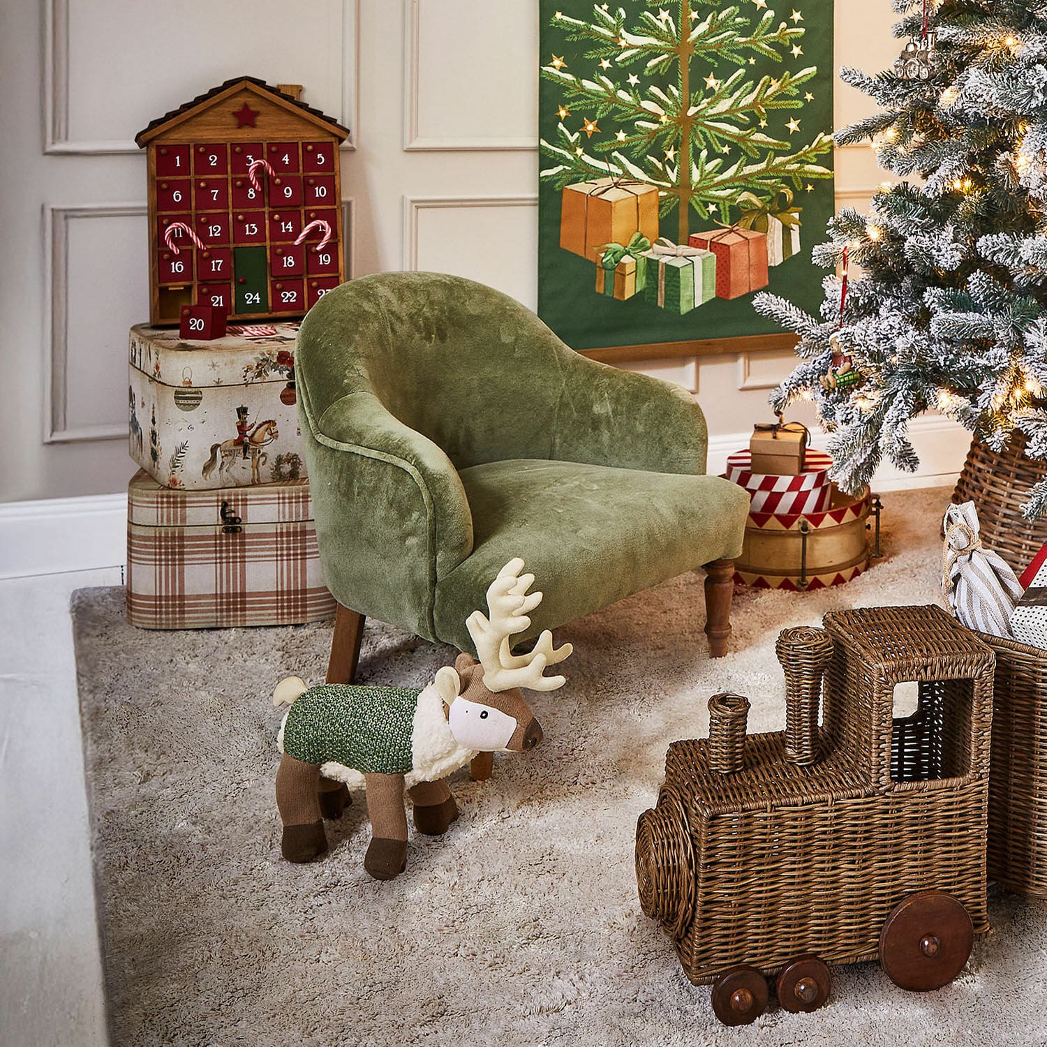 Kindersessel Rowenna Grüner Kindersessel mit Plüsch-Rentier und geflochtenem Zugspielzeug in weihnachtlich dekoriertem Zimmer