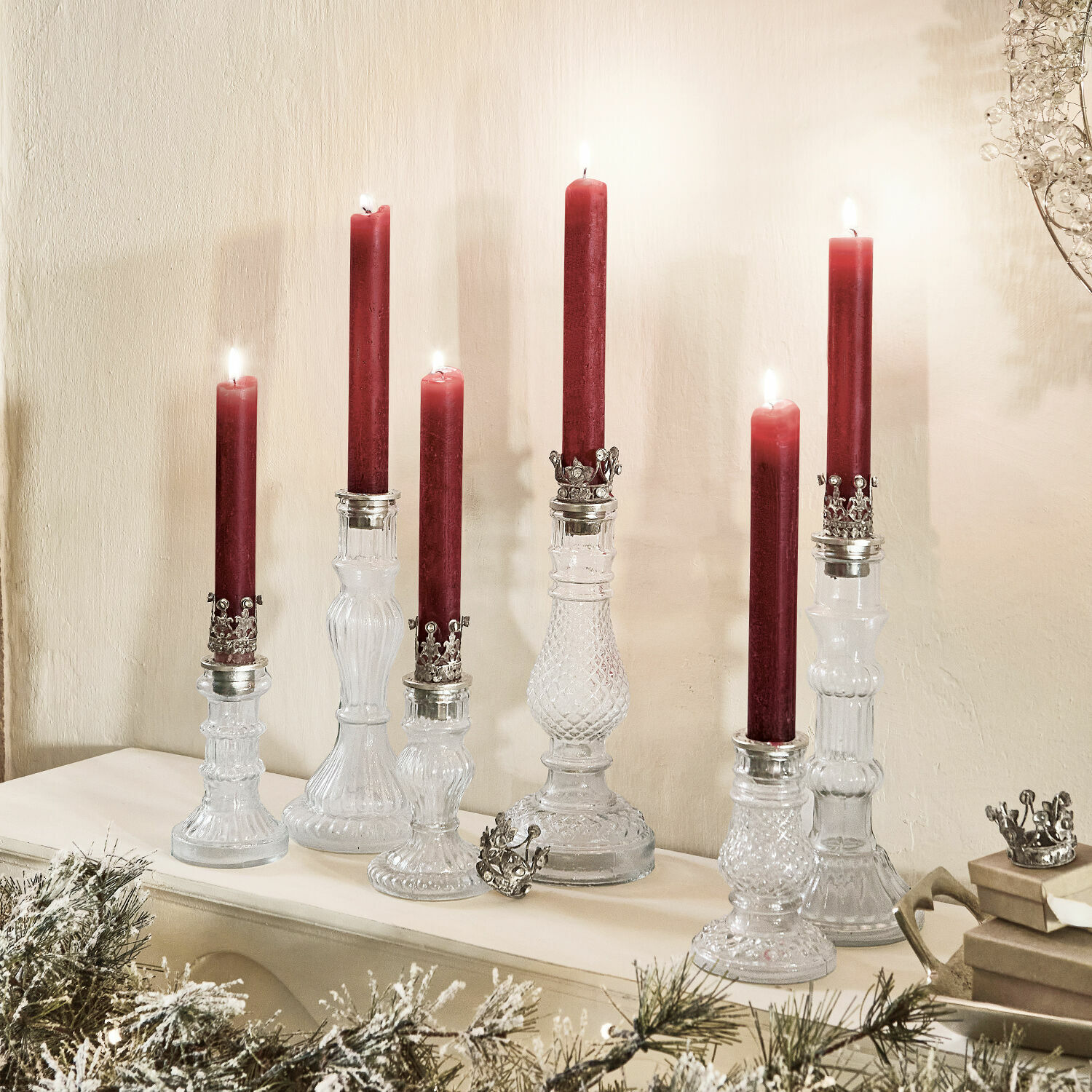Kerzenständer 6er Set Youna Set aus gläsernen Kerzenhaltern mit roten Kerzen und Metallverzierungen auf dem Kaminsims