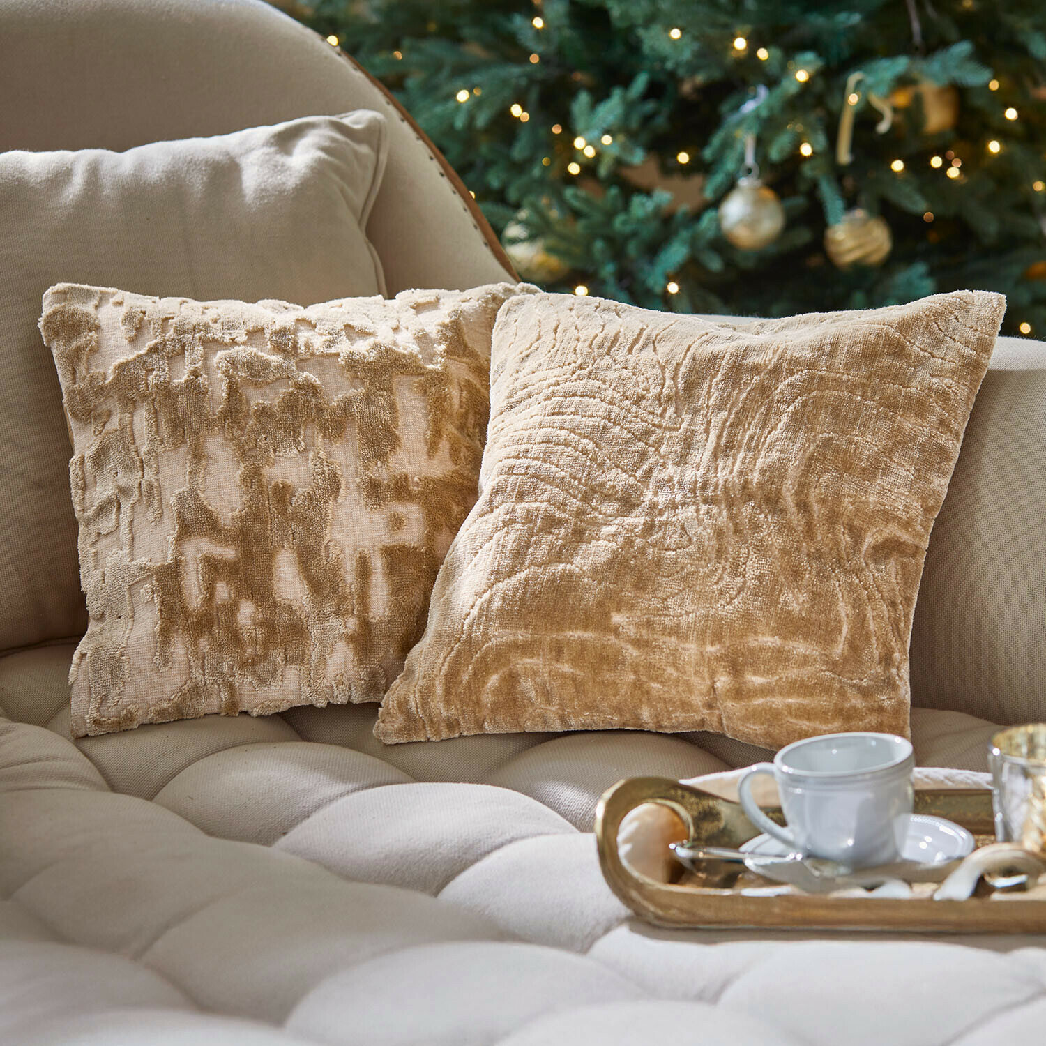 Kissenhülle 2er Set Doranza Beige Dekokissen aus weichem Stoff auf hellem Sofa, gemütliche Wohnzimmerszene mit Weihnachtsbaum
