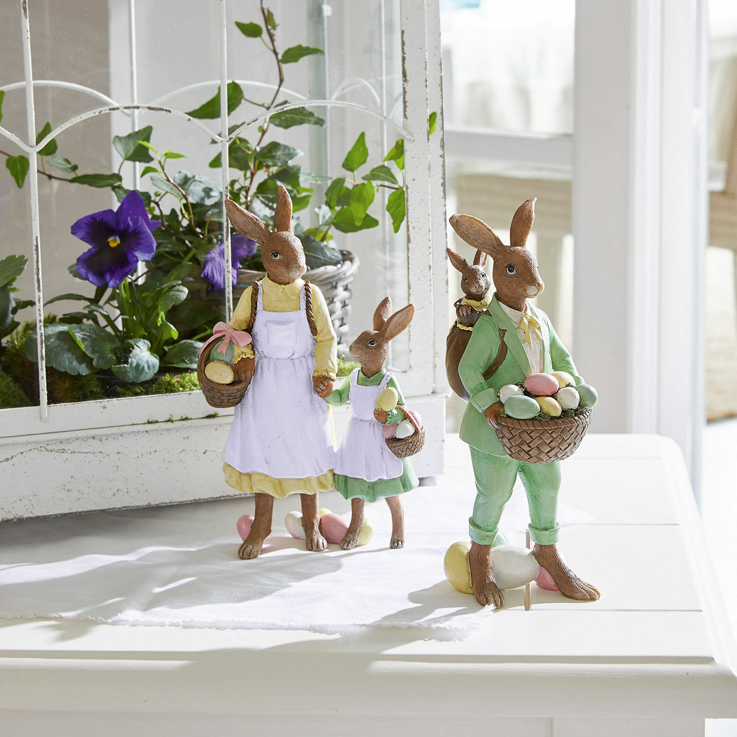 Hasen Pantina Osterhasenfiguren aus Harz mit Körben voller bunter Eier, pastellfarbene Dekoration für den Frühling
