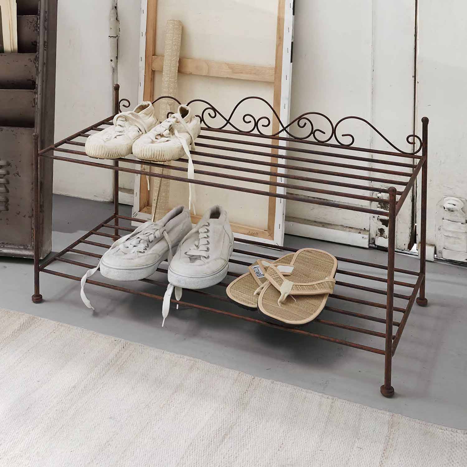 Zweistöckiges Schuhregal aus rostigem Metall im Vintage-Stil mit weissen und beigen Schuhen