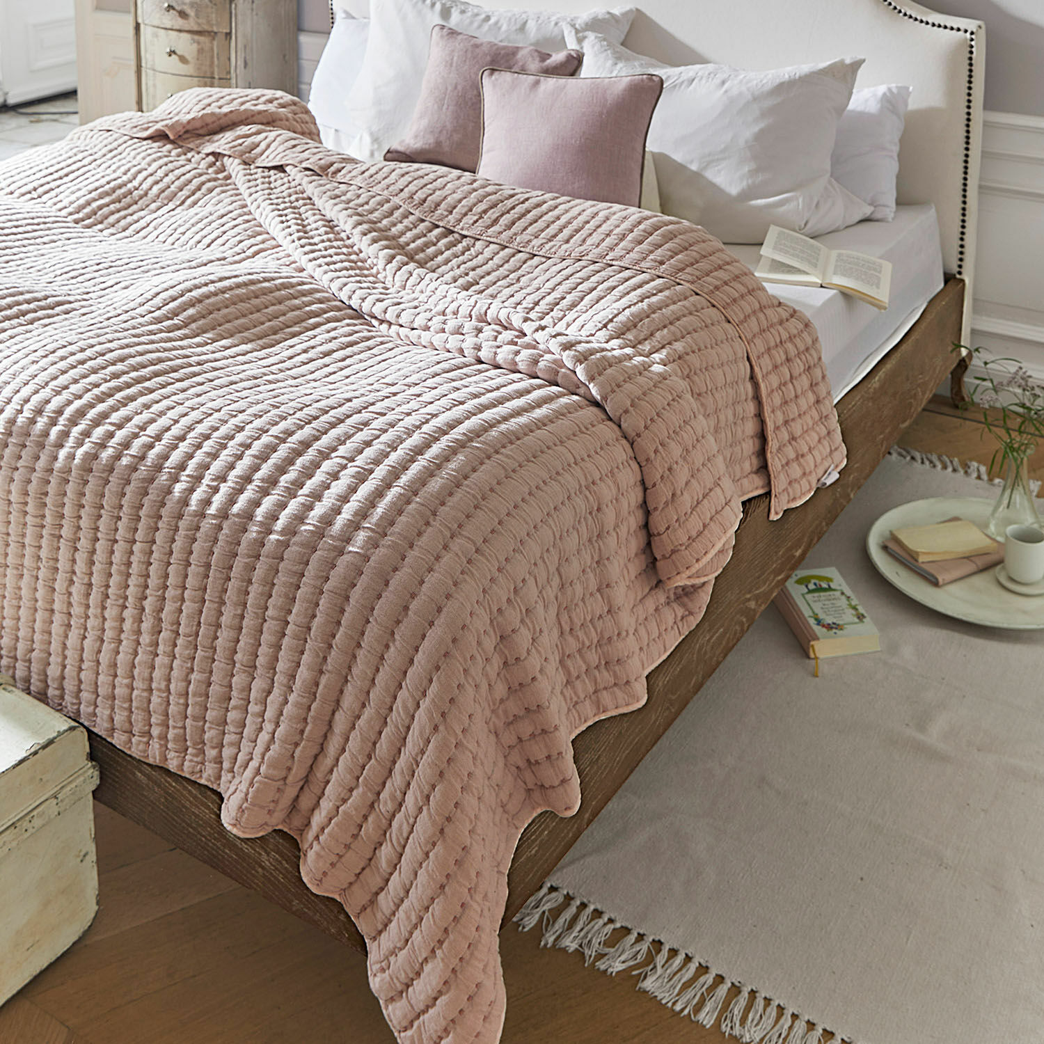Quilt Herepian Rosa gesteppte Baumwolldecke auf Holzbett mit weisser Bettwäsche in gemütlichem Schlafzimmer