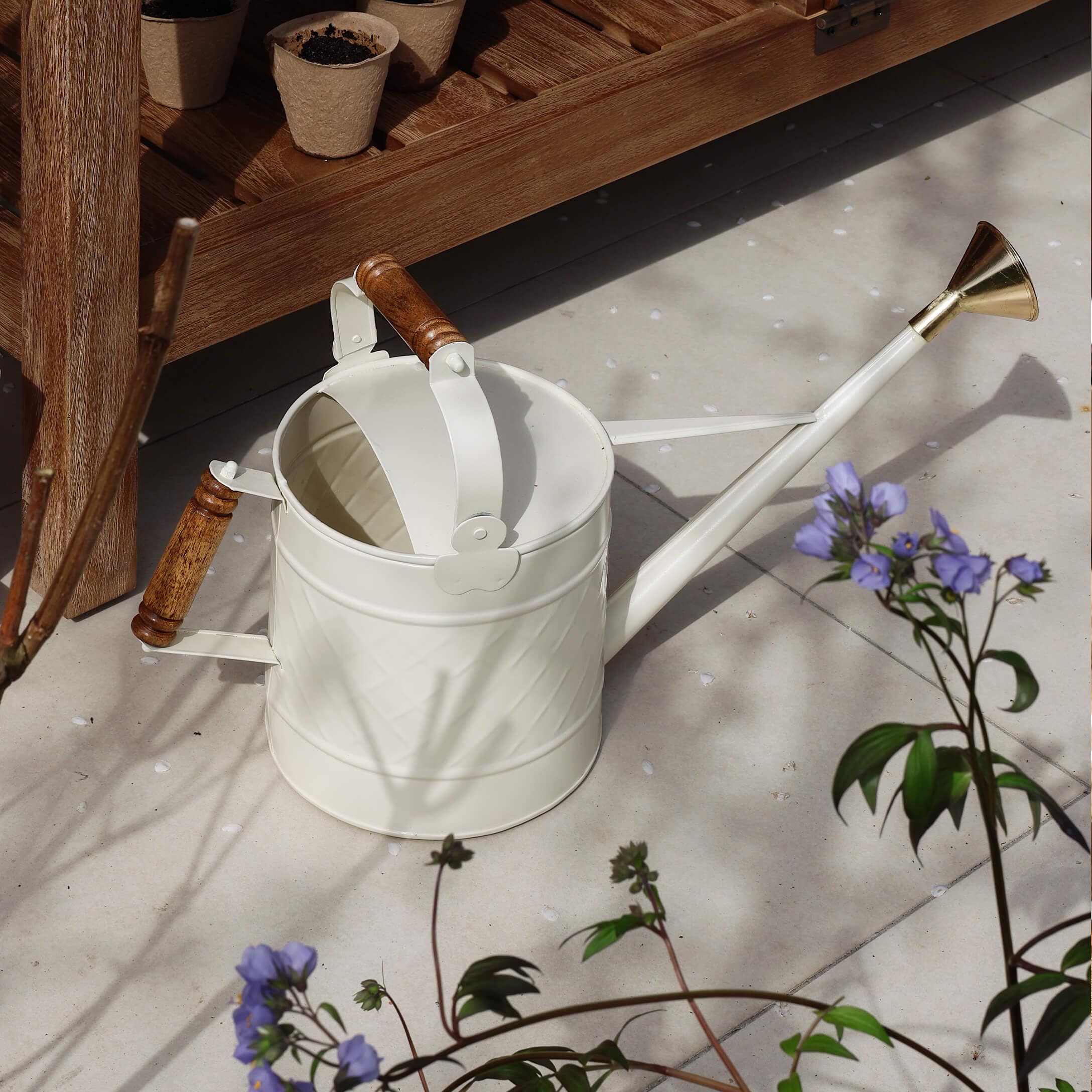 Weisse Giesskanne aus Metall mit Holzgriffen und Messingbrause für Gartenarbeit