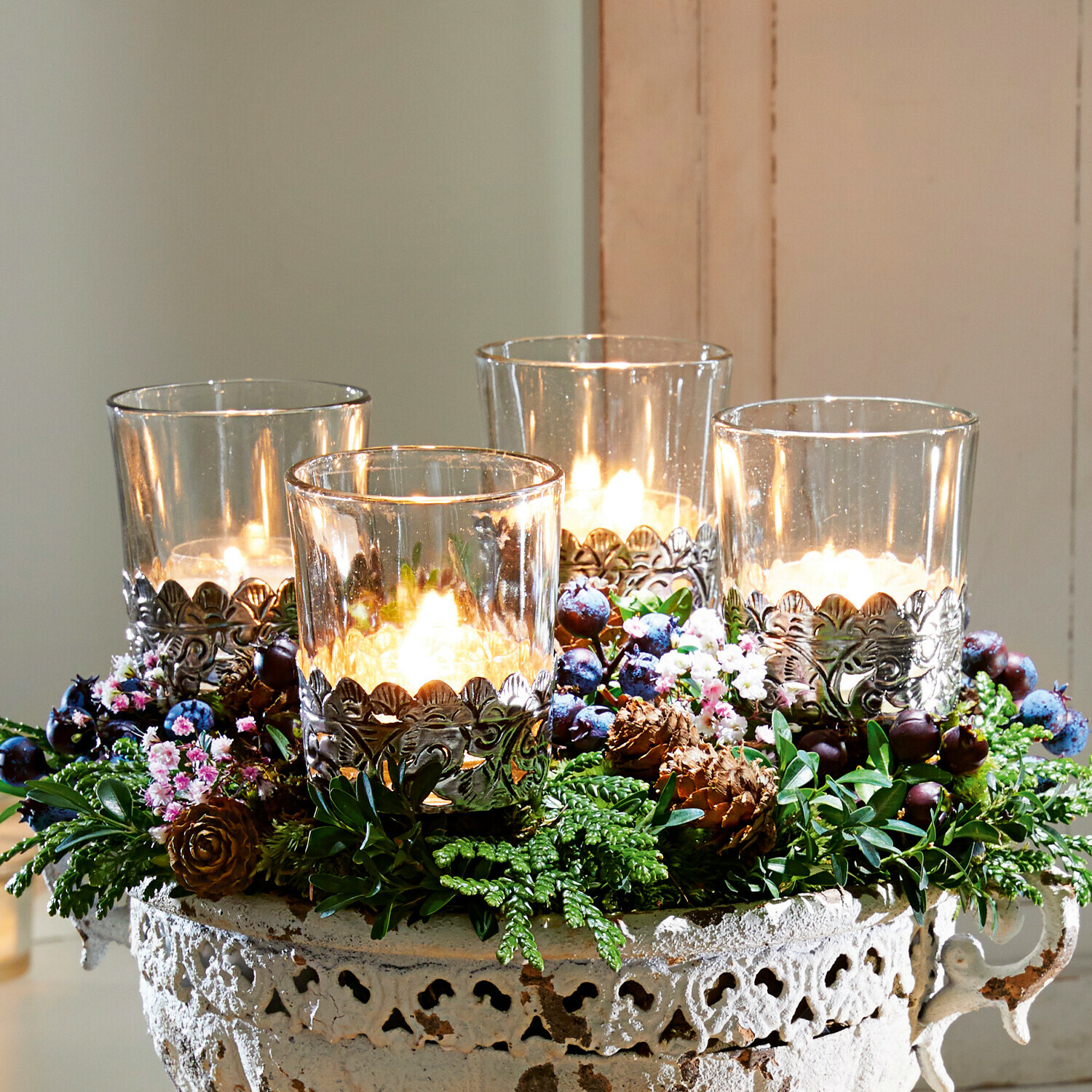 Windlicht 4er Set Pinelle Dekorative Metallschale im Vintage-Stil mit vier Kerzen und grünen Verzierungen auf Holztablett