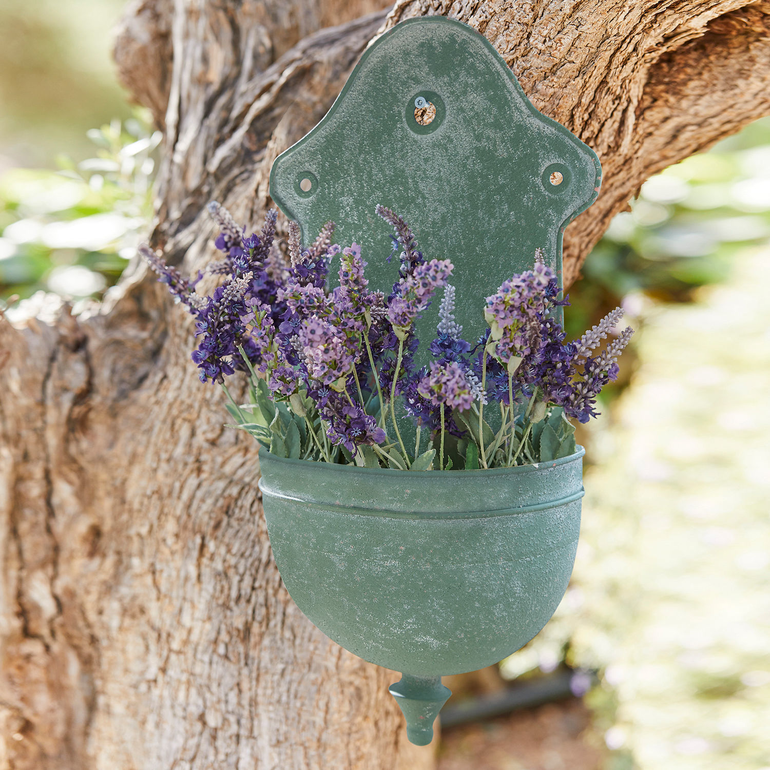Pflanzbrunnen Sedan Grüne Metall-Wandblumenvase mit violetten Lavendelblüten als Gartendekoration