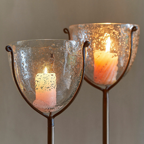 Glaswindlicht auf Metallständer mit weisser Kerze, stimmungsvolle Wohnraumdekoration