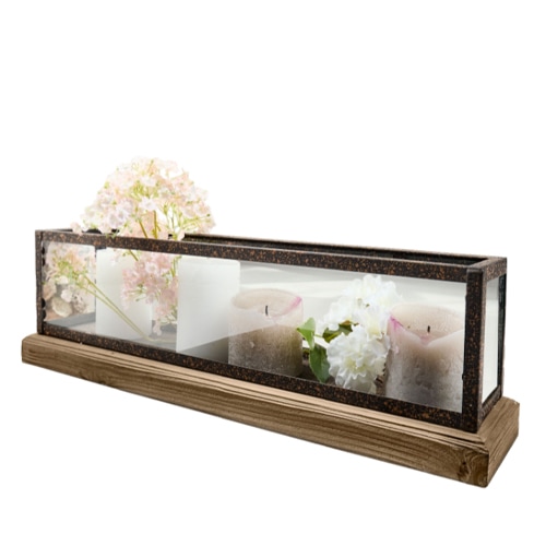 Rechteckiger Kerzenhalter aus Glas und Metall auf Holzsockel mit dekorativen Blumen und Kerzen