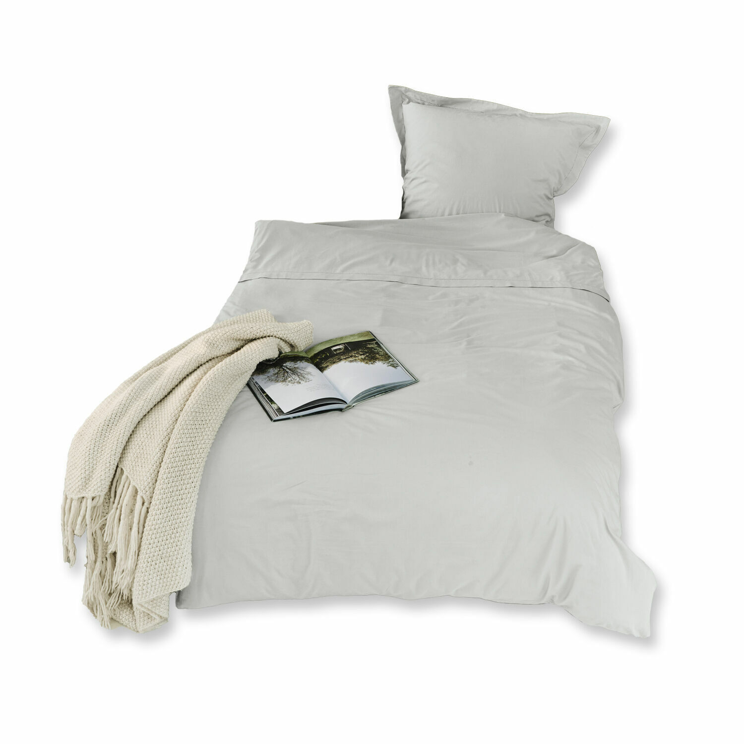 Graue Baumwoll-Bettwäsche Grosseto mit cremefarbenem Strickplaid und offenem Buch auf dem Bett