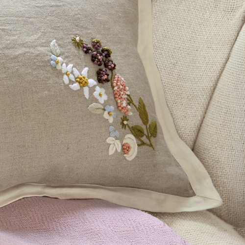 Beiges Leinenkissen mit farbiger Blumenstickerei und cremefarbenem Rand als Dekoration