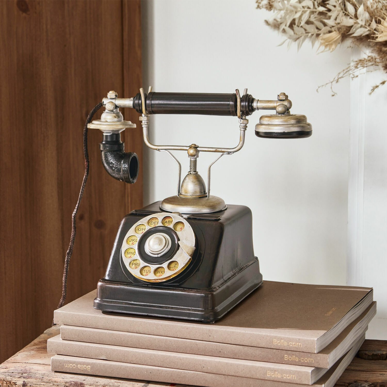 Deko-Telefon Upavon Altes schwarzes Wählscheibentelefon mit Metallteilen auf einem Stapel brauner Bücher