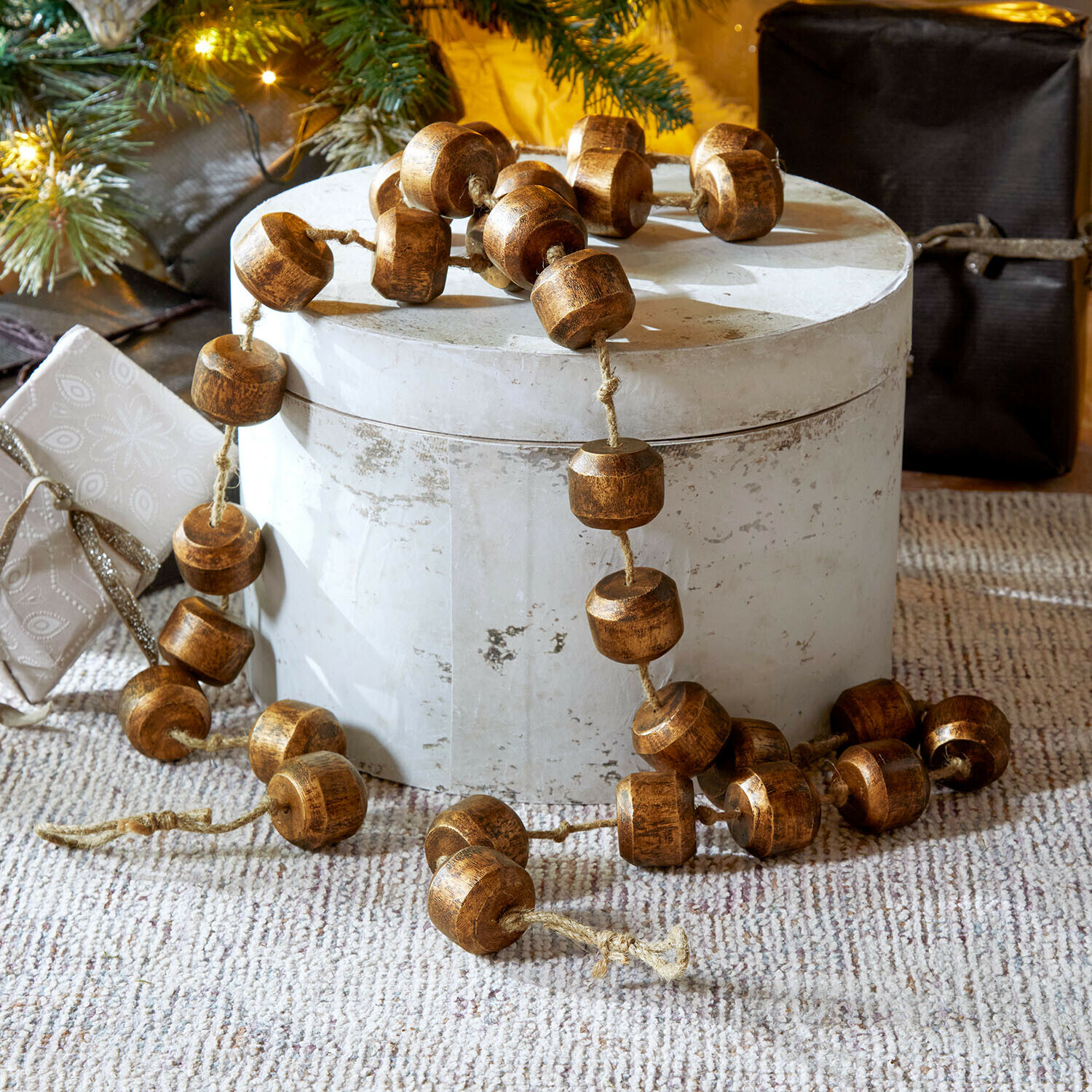 Girlande Caralinas Dekorative Kette aus braunen Holzperlen auf hellem Untergrund, festliche Weihnachtsdekoration
