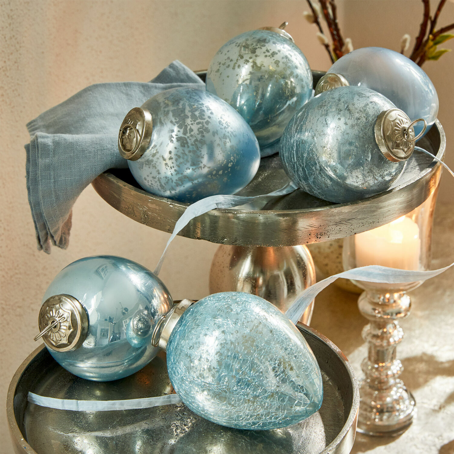 Osterei 6er Set Cataleya Set aus blauen Glas-Weihnachtskugeln mit Metallaufhängungen auf silbernem Dekotablett