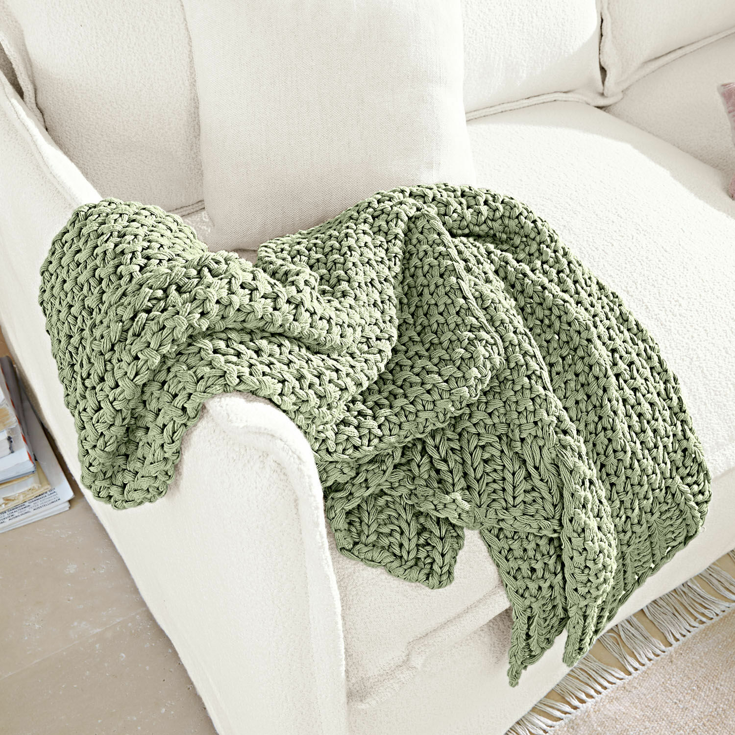 Plaid Plixoren Weiche, grün grob gestrickte Decke auf weissem Sofa, gemütliche Wohnraumdekoration