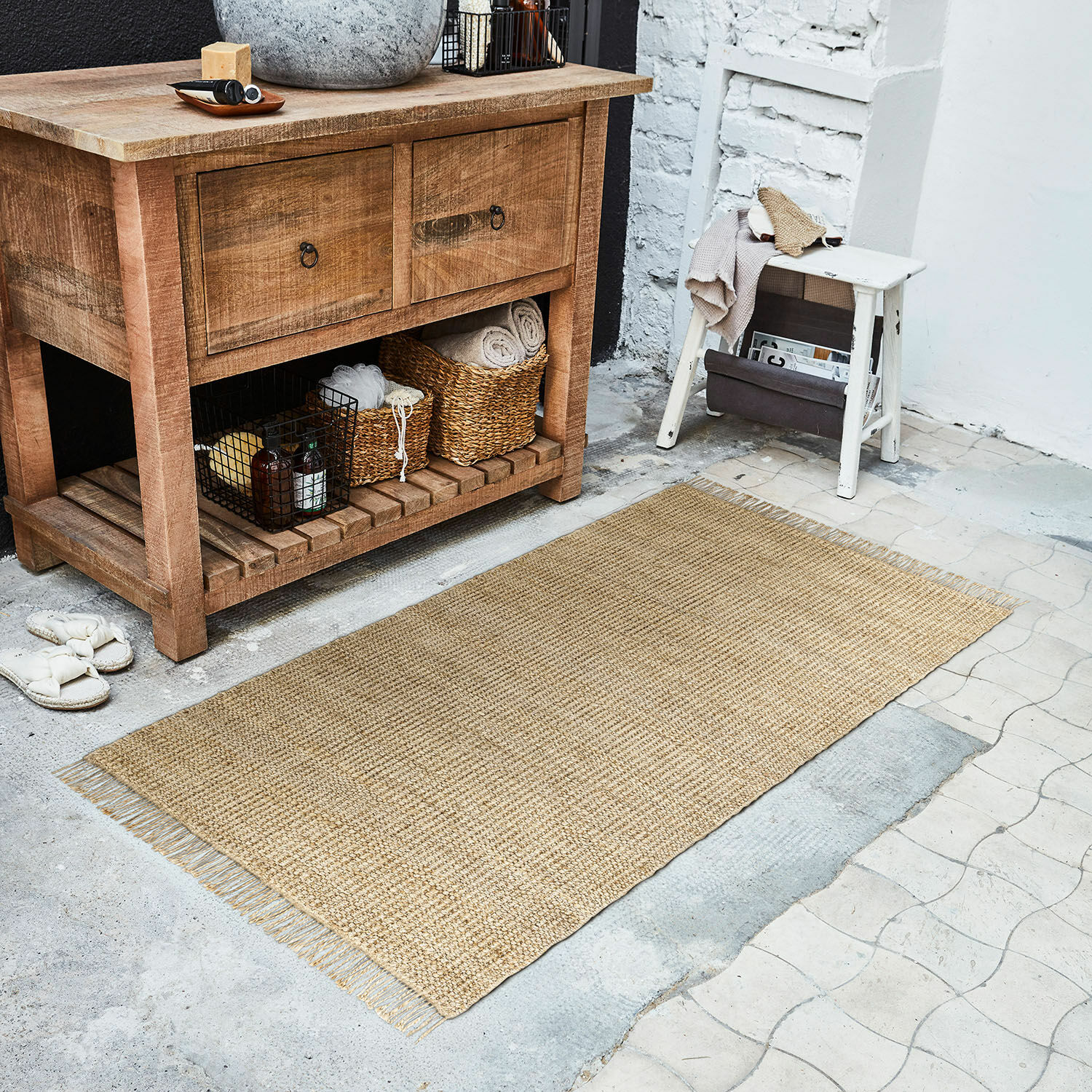 Läufer Hermitage Natürlicher Juteteppich in Beige auf dem Boden neben einer Holzkommode und einem weissen Hocker