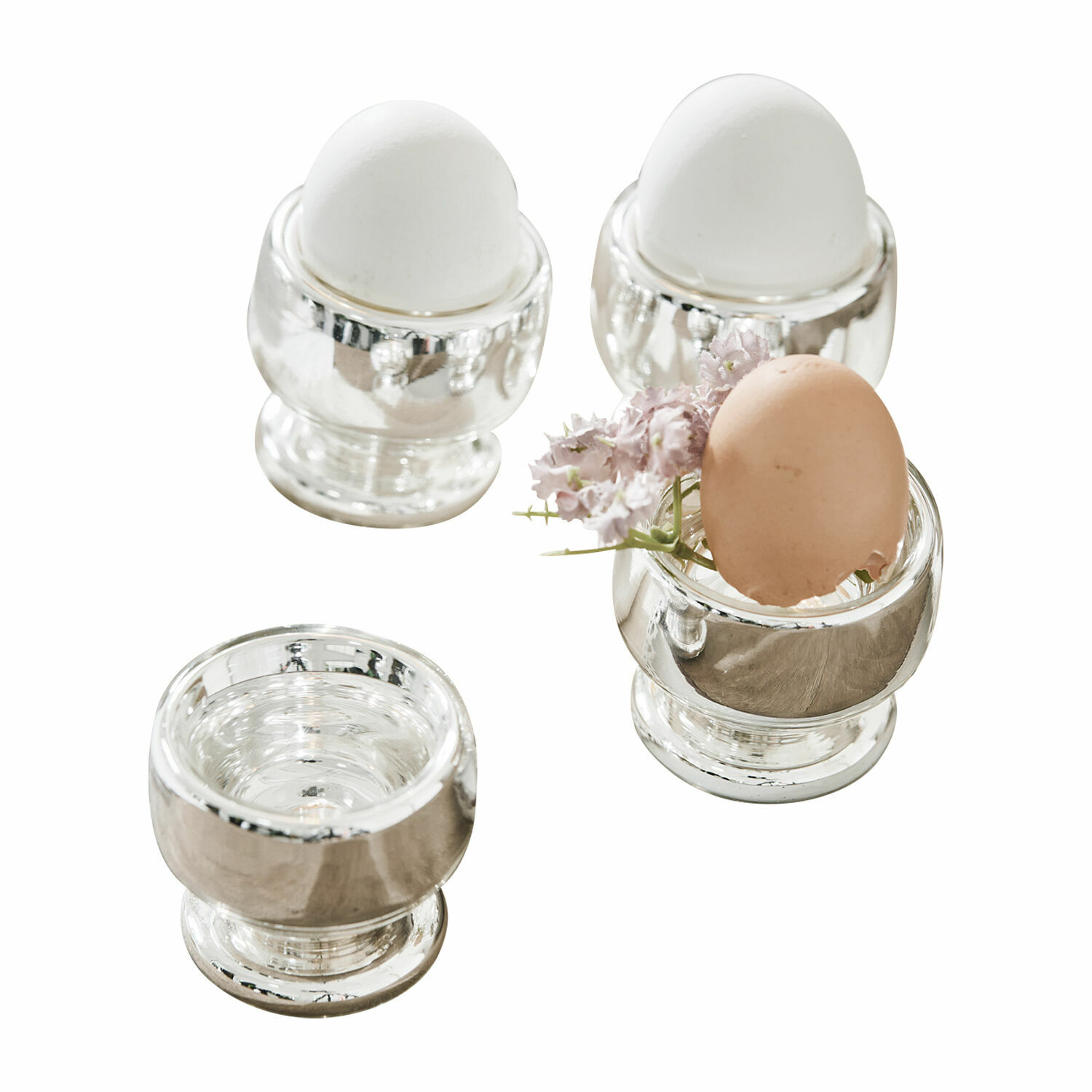 Eierbecher 4er Set Lilligret Vier silberne Metall-Eierbecher mit weissen und braunen Eiern sowie einer kleinen Blume als Dekoration