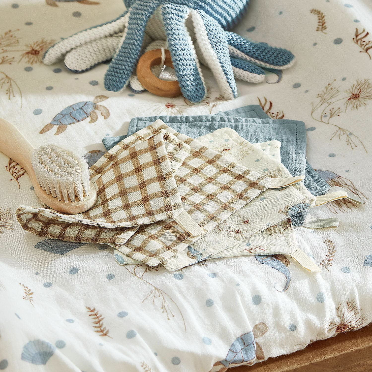 Waschlappen 6er Set Tinkertop Set aus Baumwollwindeln mit Karomuster und Meeresmotiven auf Babybett mit weicher Bürste